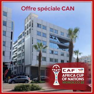 a sign in front of a building with palm trees at Grand 3 pièces de standing, confort premium in Casablanca