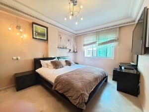 a bedroom with a bed and a television in it at Grand 3 pièces de standing, confort premium in Casablanca