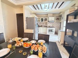 a kitchen with a table with plates of food on it at Grand 3 pièces de standing, confort premium in Casablanca +44 photos