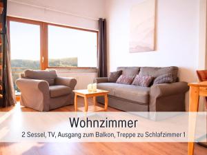 een woonkamer met een bank en een tafel bij SONNENSEITE Schonach - Für Paare und Ruhesuchende - Private Infrarotsauna - 2 SZ - Küche mit Spülmaschine und Mikrowelle - 300 m zum Waldrand - Parkplatz direkt am Haus in Schonach