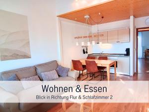 een woonkamer met een bank en een tafel bij SONNENSEITE Schonach - Für Paare und Ruhesuchende - Private Infrarotsauna - 2 SZ - Küche mit Spülmaschine und Mikrowelle - 300 m zum Waldrand - Parkplatz direkt am Haus in Schonach