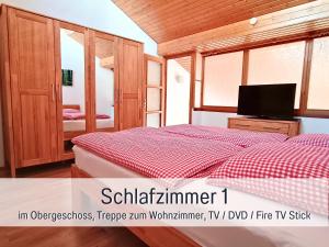 een slaapkamer met een bed en een tv erin bij SONNENSEITE Schonach - Für Paare und Ruhesuchende - Private Infrarotsauna - 2 SZ - Küche mit Spülmaschine und Mikrowelle - 300 m zum Waldrand - Parkplatz direkt am Haus in Schonach