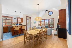 a kitchen and living room with a table and chairs at Les Eaux 3BR, Sauna, Fireplace and Jacuzzi Access in Mont-Tremblant