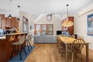 a kitchen and living room with a table and chairs at Les Eaux 3BR, Sauna, Fireplace and Jacuzzi Access in Mont-Tremblant
