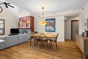 a kitchen and dining room with a table and chairs at Les Eaux 3BR, Sauna, Fireplace and Jacuzzi Access in Mont-Tremblant