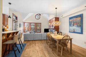 a kitchen and living room with a table and chairs at Les Eaux 3BR, Sauna, Fireplace and Jacuzzi Access in Mont-Tremblant +28 photos