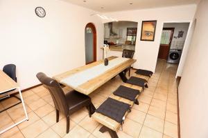 a dining room with a wooden table and chairs at African Oasis Cameroon in Somerset West