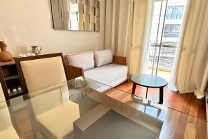 ein Wohnzimmer mit einer Couch und einem Glastisch in der Unterkunft Village in Viçosa