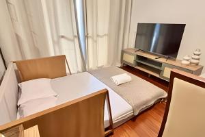 ein kleines Zimmer mit einem Bett und einem Flachbildfernseher in der Unterkunft Village in Viçosa