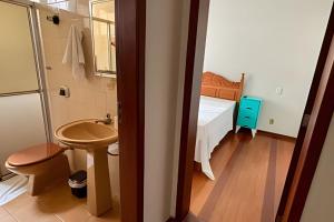 ein kleines Badezimmer mit Waschbecken und Bett in der Unterkunft Village in Viçosa + 49 Fotos