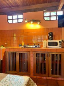 eine Küche mit einer Arbeitsfläche, auf der eine Mikrowelle steht in der Unterkunft Apartamento Boruca Tamarindo in Tamarindo + 5 Fotos