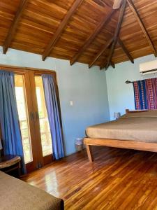 1 Schlafzimmer mit 2 Betten und Holzboden in der Unterkunft Apartamento Boruca Tamarindo in Tamarindo