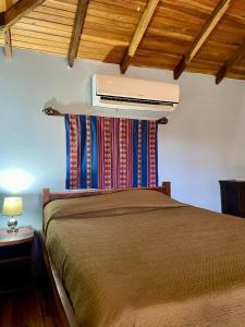 ein Schlafzimmer mit einem Bett und einer Klimaanlage an der Wand in der Unterkunft Apartamento Boruca Tamarindo in Tamarindo