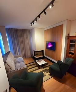 a living room with a couch and a tv at Tribeca Gramado 12 in Gramado