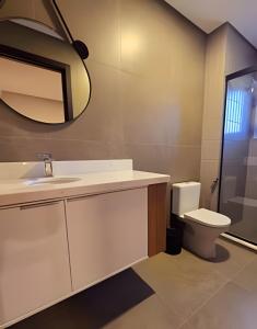 a bathroom with a sink and a toilet and a mirror at Tribeca Gramado 12 in Gramado +15 photos