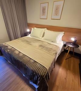 a bedroom with a large bed with two tables at Tribeca Gramado 12 in Gramado