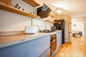 a kitchen with blue cabinets and a counter top at The Winkle - Elie in Elie +42 photos