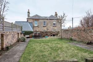 an old brick house with a yard in front of it at The Winkle - Elie in Elie