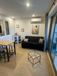 un salon avec un canapé noir et une table dans l'établissement vacances au soleil, à Cagnes-sur-Mer