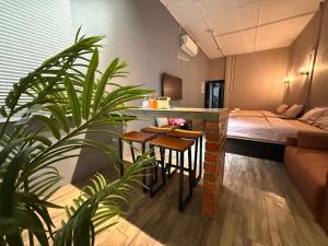 een kamer met een bed en een tafel en een plant bij Ipoh Zing Vale - Family & Couple Suite in Ipoh