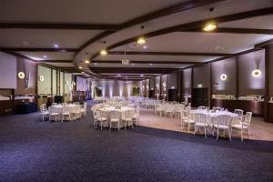 a banquet hall with white tables and white chairs at Radisson Blu Hotel, Florence in Florence