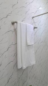two white towels hanging on a towel rack in a bathroom at Tanya's Cafe & Resort in Ban Kasang