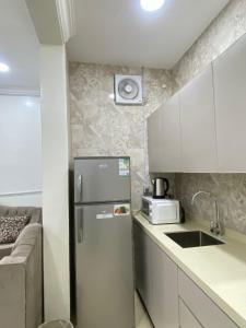 una piccola cucina con frigorifero e forno a microonde di شقق vip a Al Hofuf Altre 15 foto