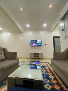 un soggiorno con un divano e una TV a parete di شقق vip a Al Hofuf