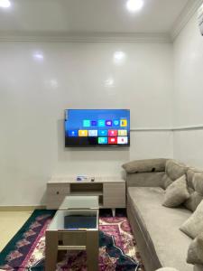 un soggiorno con divano e TV a schermo piatto di شقق vip a Al Hofuf