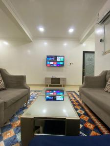 un soggiorno con due divani e una TV di شقق vip a Al Hofuf