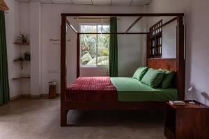 a bedroom with a canopy bed with a window at Ayana wellness resort in Talpe +3 photos