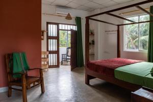 a bedroom with a bed and a chair and a window at Ayana wellness resort in Talpe