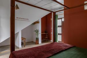 a bedroom with a bed in a room with orange walls at Ayana wellness resort in Talpe