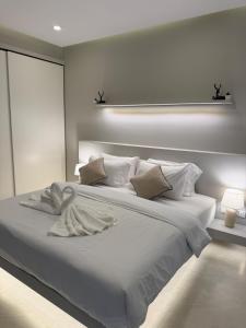 een witte slaapkamer met een groot wit bed met kussens bij CH Villa Sand Stone in Ko Samui +10 foto's