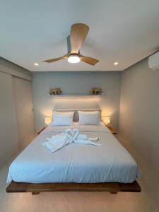 een slaapkamer met een bed met een plafondventilator bij CH Villa Sand Stone in Ko Samui
