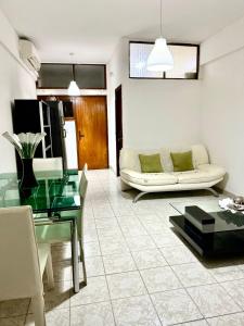 een woonkamer met een bank en een glazen tafel bij Maianga Flat in Luanda