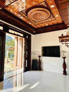 a room with a ceiling with a television and vases at Nutty Village Phu Quoc in Phú Quốc