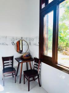 a room with a table and two chairs and a mirror at Nutty Village Phu Quoc in Phú Quốc +17 photos