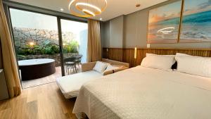 een hotelkamer met een bed, een stoel en een bad bij W Tambaú Apart Hotel in João Pessoa +49 foto's