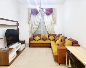 ein Wohnzimmer mit Sofa und Fernseher in der Unterkunft City Lights holiday home in Ajman  + 9 Fotos