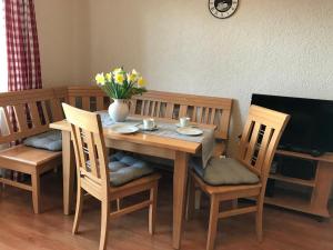 een tafel en stoelen met een vaas met bloemen erop bij Ferienwohnung Hirtreiter in Lalling
