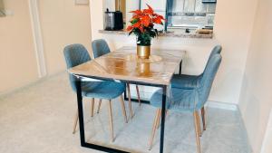 a dining room table with blue chairs and a vase with flowers at Apartment Fontana Golf Villamartin in Orihuela Costa