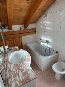 a bathroom with a sink and a tub and a toilet at L'Atelier du Temps - Chalet Pompon in Cogne +47 photos