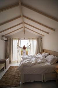 een vrouw in een slaapkamer die uit het raam kijkt bij Bela Vista Hotel Boutique in Caraíva