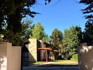 een huis in het midden van een tuin met bomen bij Complejo Malama Kai in Mar de Cobo