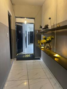 een kamer met een gang met een spiegel en bloemen bij Hotel saffire in Feira de Santana