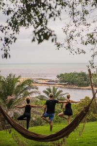 drie mensen die in een hangmat aan het strand aan het hardlopen zijn bij Bela Vista Hotel Boutique in Caraíva +175 foto's