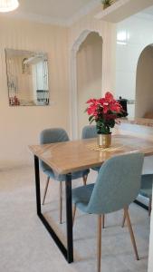 a dining room table with a vase of flowers on it at Apartment Fontana Golf Villamartin in Orihuela Costa