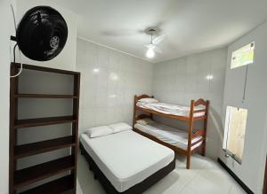 a small room with a bunk bed and a fan at Marujo da Gávea in Prado +47 photos