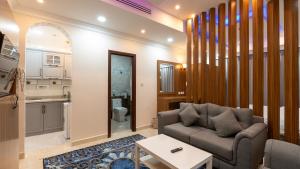 a living room with a couch and a kitchen at شقق المتألق الحديثة الفندقية in Dammam